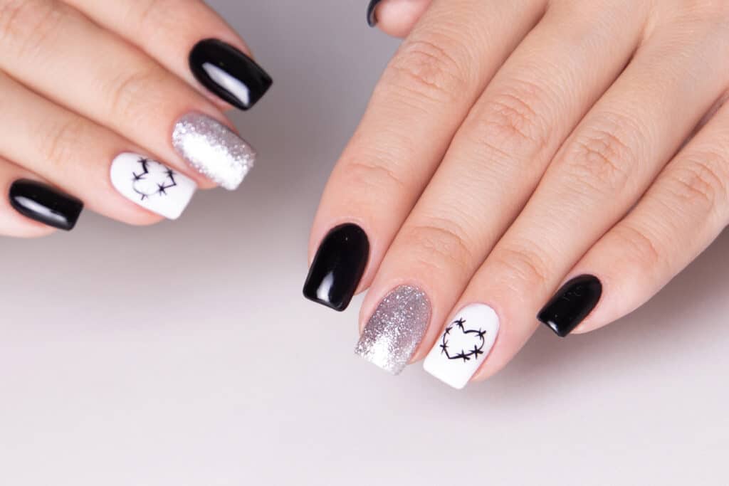 Female hands with black manicure nails hearts design