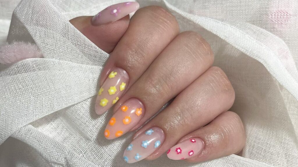 a female hand with color floral pattern on each nail