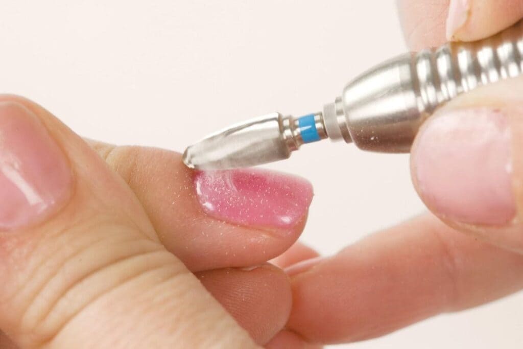 A view of polygel nails being removed with a drill x