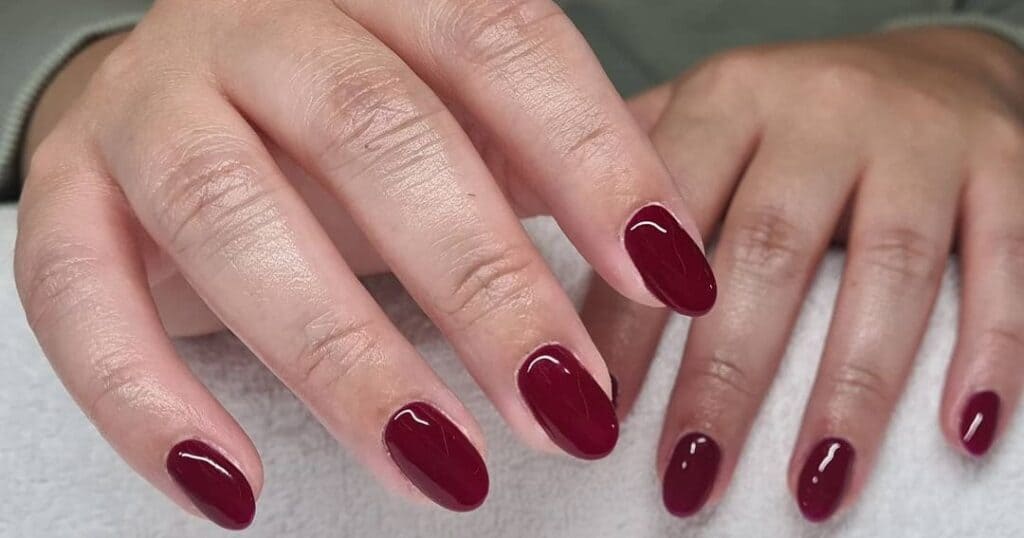 Two hands displaying burgundy glossy nails x