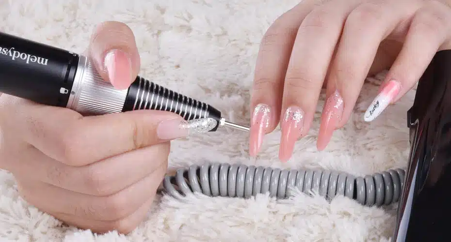 View of a girl using a driller on her poly gel nails to remove them