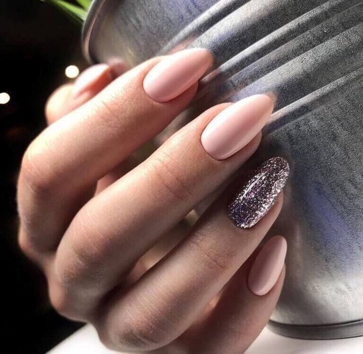 a girl hand pink with dark glitter accentr nails