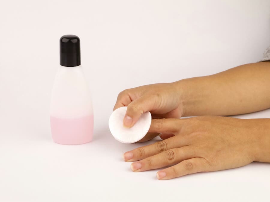 a girl is using nail polish remover to remove the nail polish