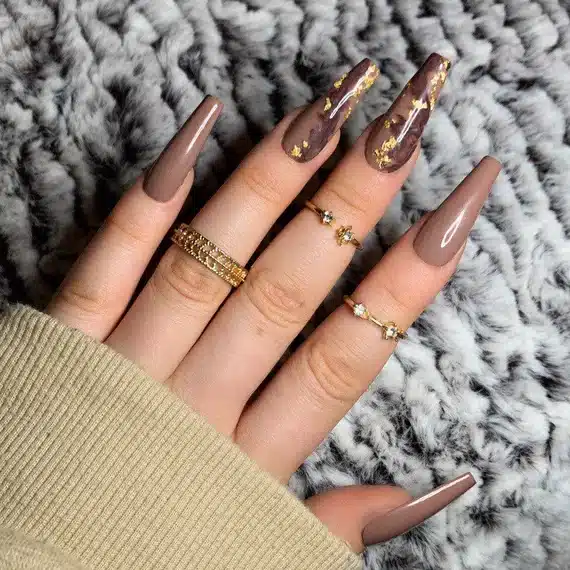 brown nails with gold foil on two accent nails rings in fingers brown nails with gold foil on two accent nails rings in fingers