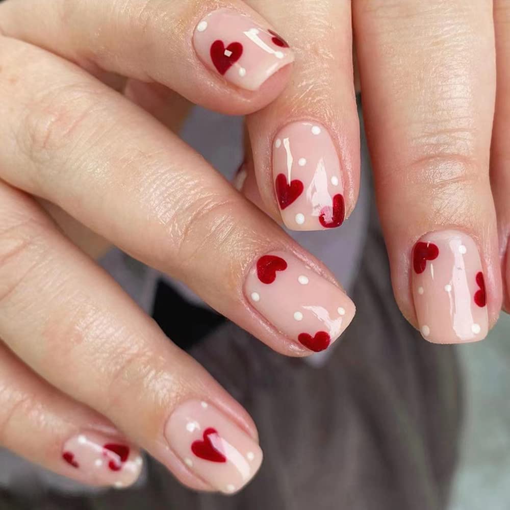 Version woman's hands with red itty bitty nails and white dots on them