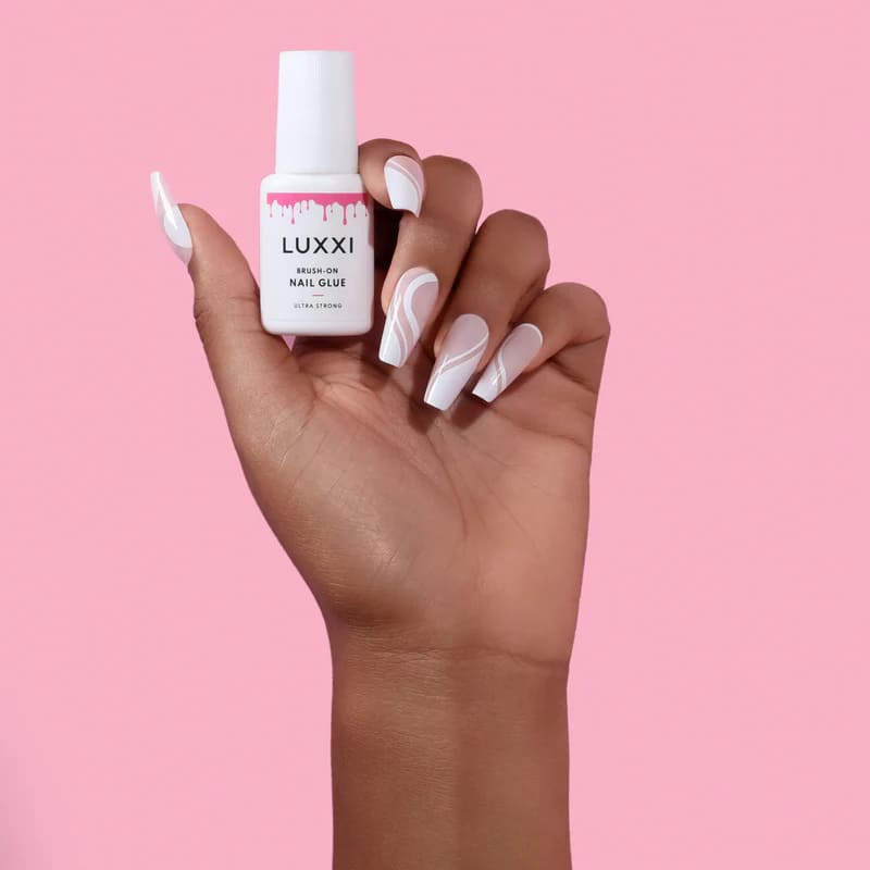 womens hand holding a nail glue