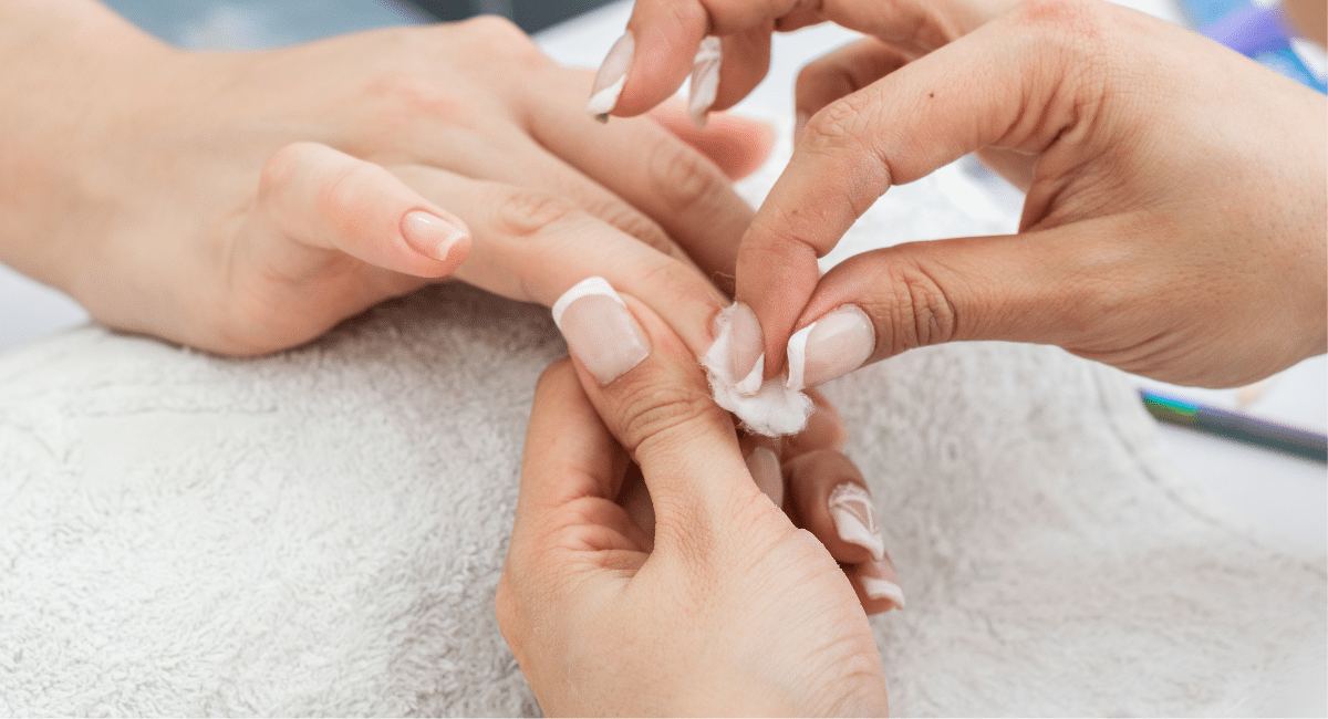 zoomed in view of girl's hands removing polygel nails