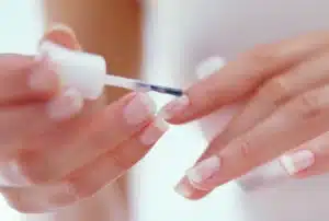 A view of a girl applying top coat of nail polish jpg