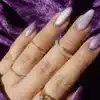 zoomed in view of a female hand with rings and lavender glittered nails jpg