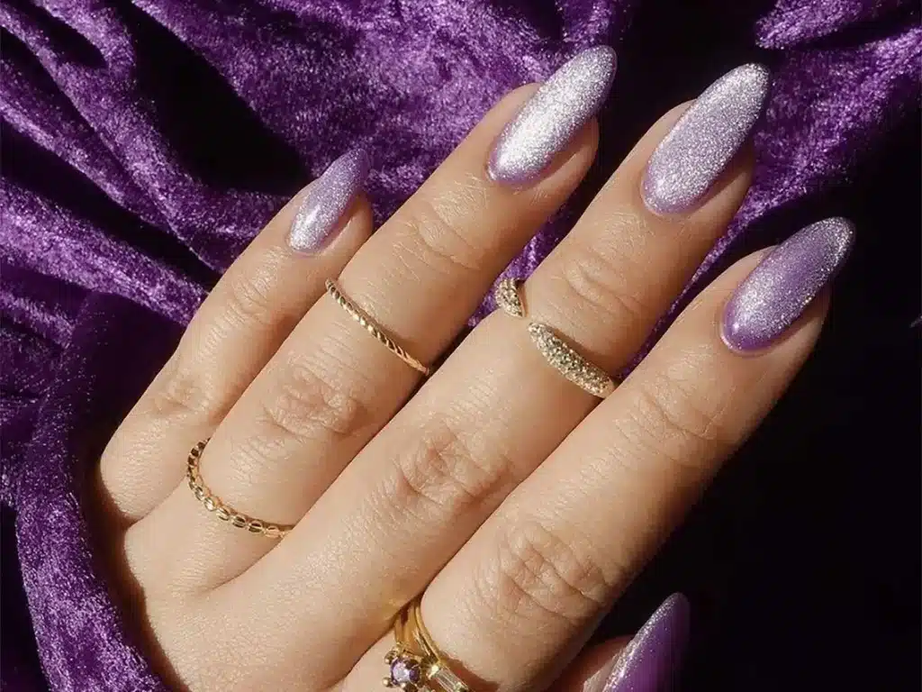 zoomed in view of a female hand with rings and lavender glittered nails jpg