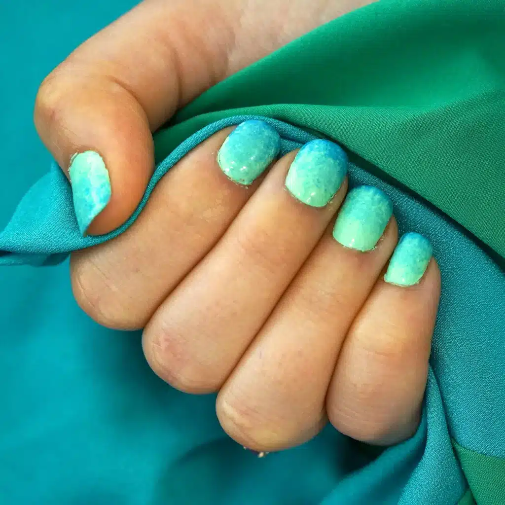 A view of hands with teal nails A view of hands with teal nails