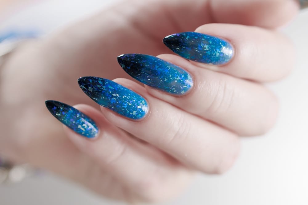 Female Hand With Long Nails And Blue black Thermo French Nail