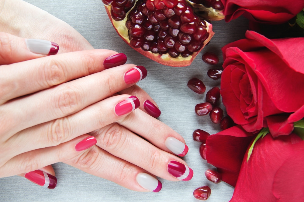 female hands with grey pink and red asymmetry nail art manicure