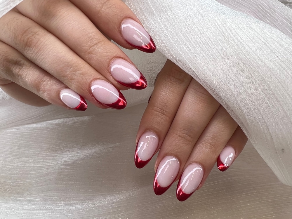 female hands with pink nail paint and red tips