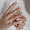 female hands showing off her white bridal nails
