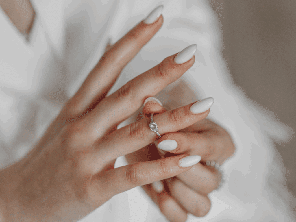 female hands showing off her white bridal nails
