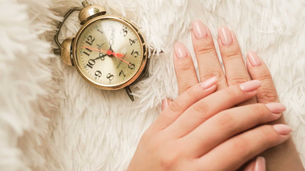 A top view of hands with gel nails and a watch on the side A top view of hands with gel nails and a watch on the side
