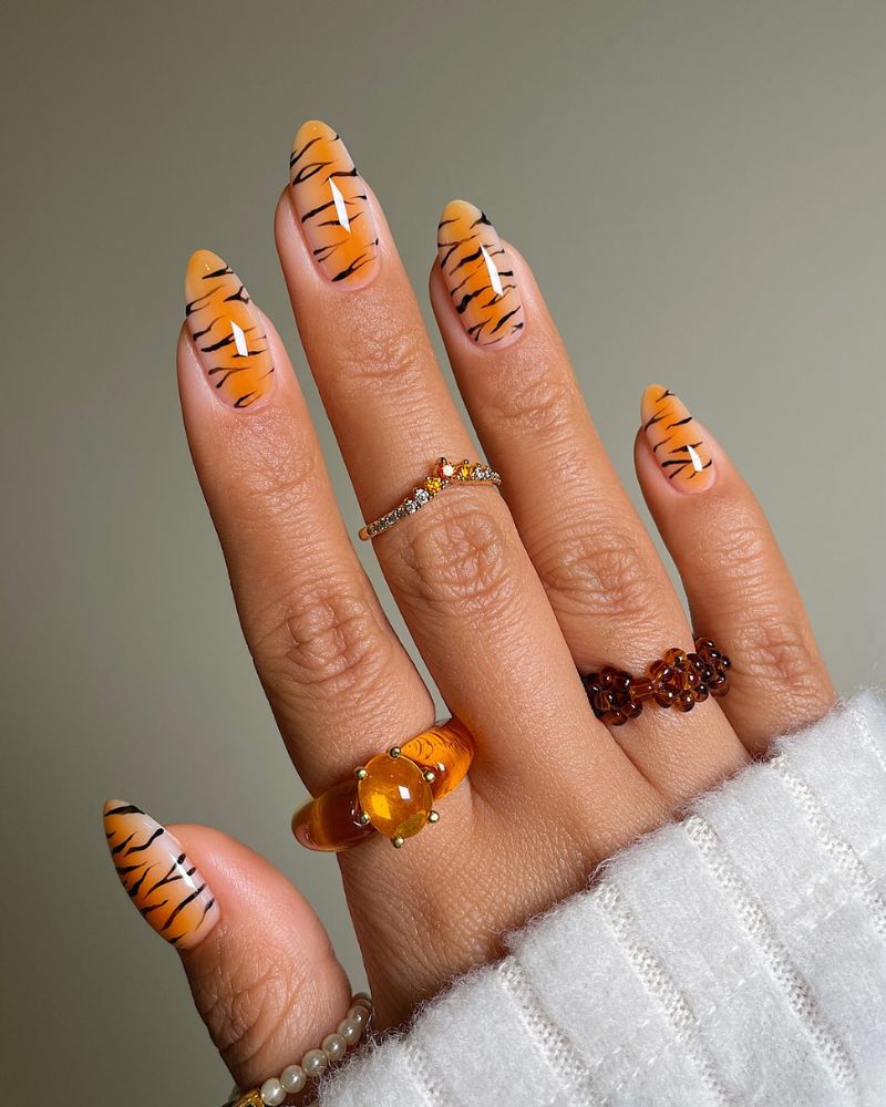 A view of tiger patterned orange nails A view of tiger patterned orange nails