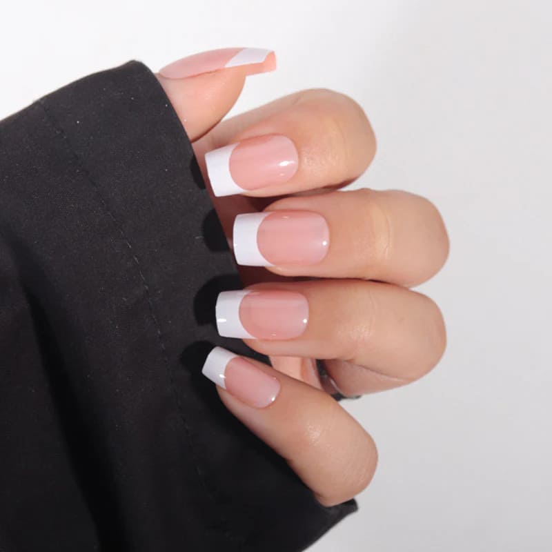 A hand showing off simple white french manicure square shape A hand showing off simple white french manicure square shape