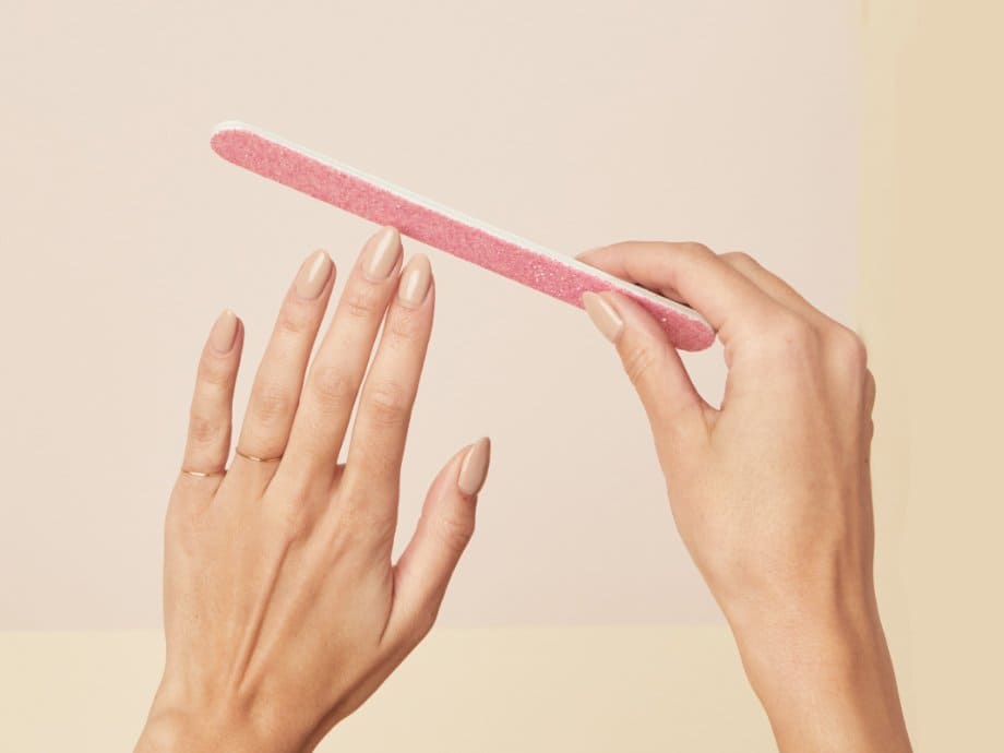A view of hands holding a filer to their press on nails A view of hands holding a filer to their press on nails