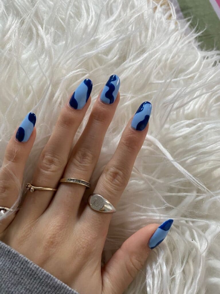 A view of hands with blue color blocking nail art x A view of hands with blue color blocking nail art x