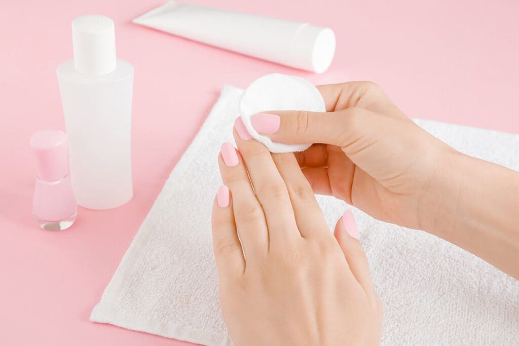 Hands using cotton swabs with acetone to remove nail polish off polygel nails x Hands using cotton swabs with acetone to remove nail polish off polygel nails x