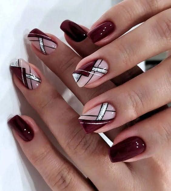 Two hands on one another showing off geometric burgundy nail art