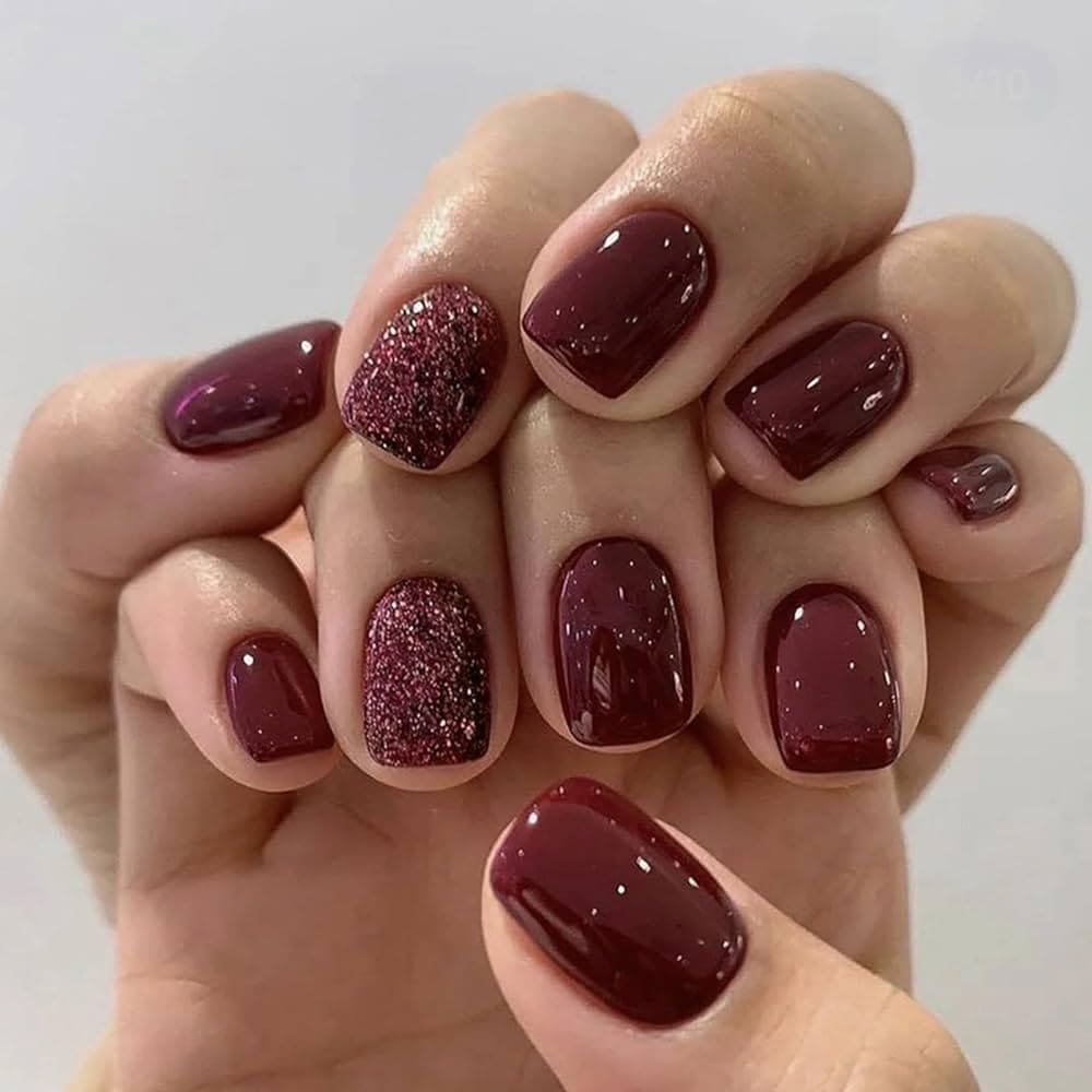 Two hands on top of each other showing burgundy glittery nails