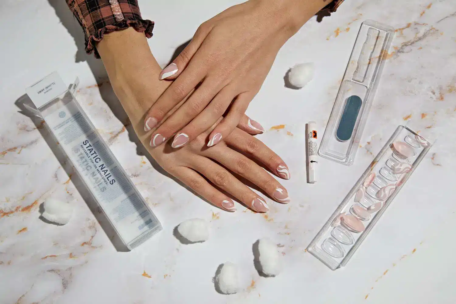 A top view of a girl s hands with press on nails and all the items from the tool kit jpg A top view of a girl s hands with press on nails and all the items from the tool kit jpg