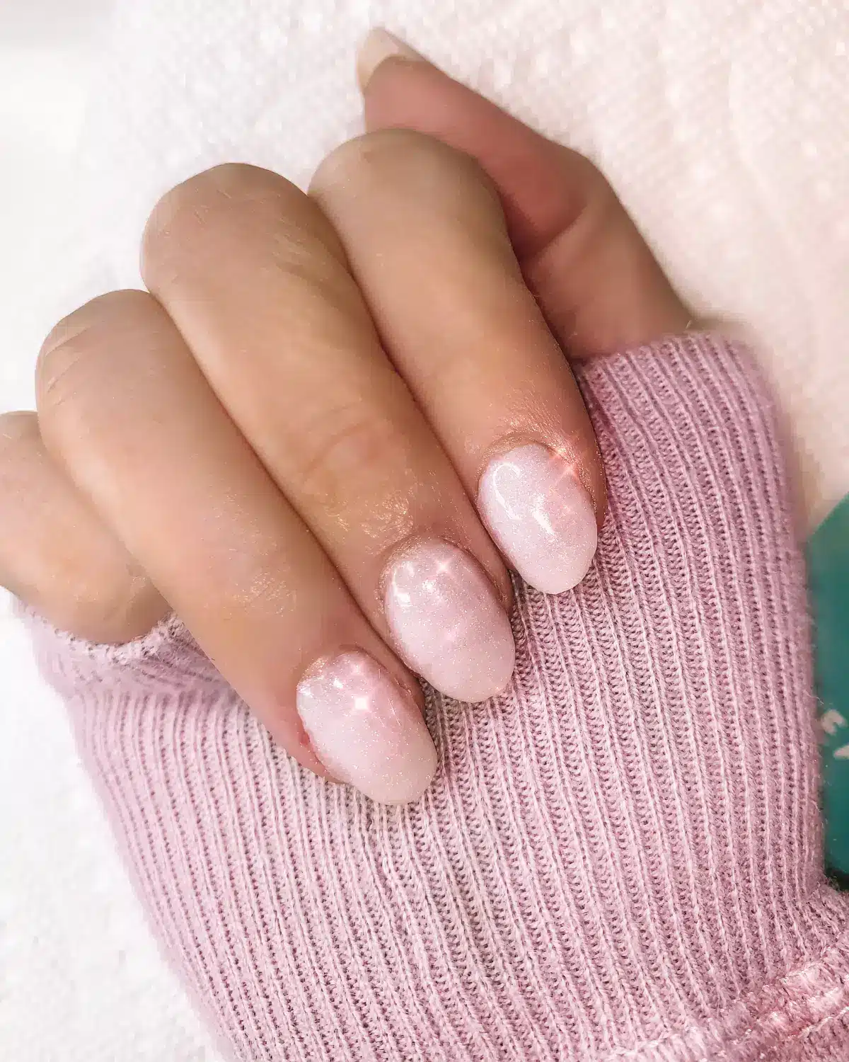 A view of hands wearing rounded baby pink press on nails with shine png A view of hands wearing rounded baby pink press on nails with shine png