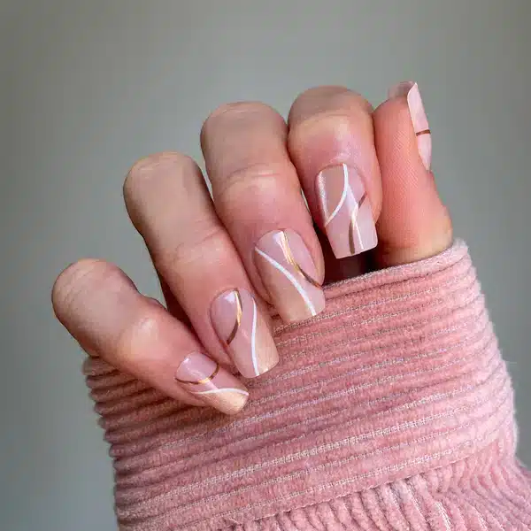 A view of pink square press on nails with golden design A view of pink square press on nails with golden design