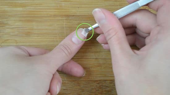 view of a female hand fixing a broken nail view of a female hand fixing a broken nail