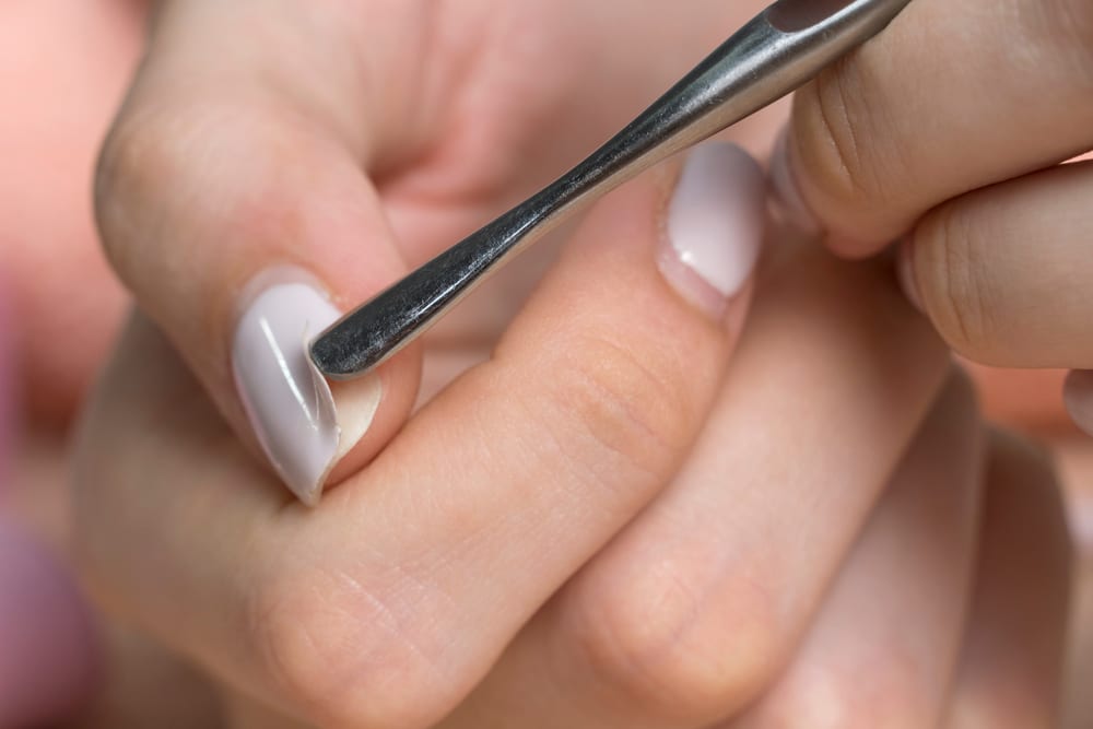 A view of hands removing gel polish off nails A view of hands removing gel polish off nails