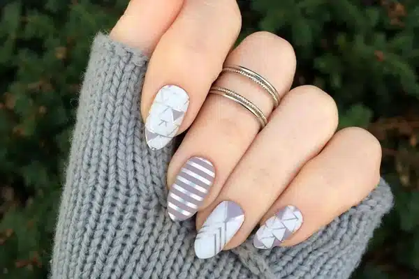 A view of hands showing off grey and white nail color A view of hands showing off grey and white nail color