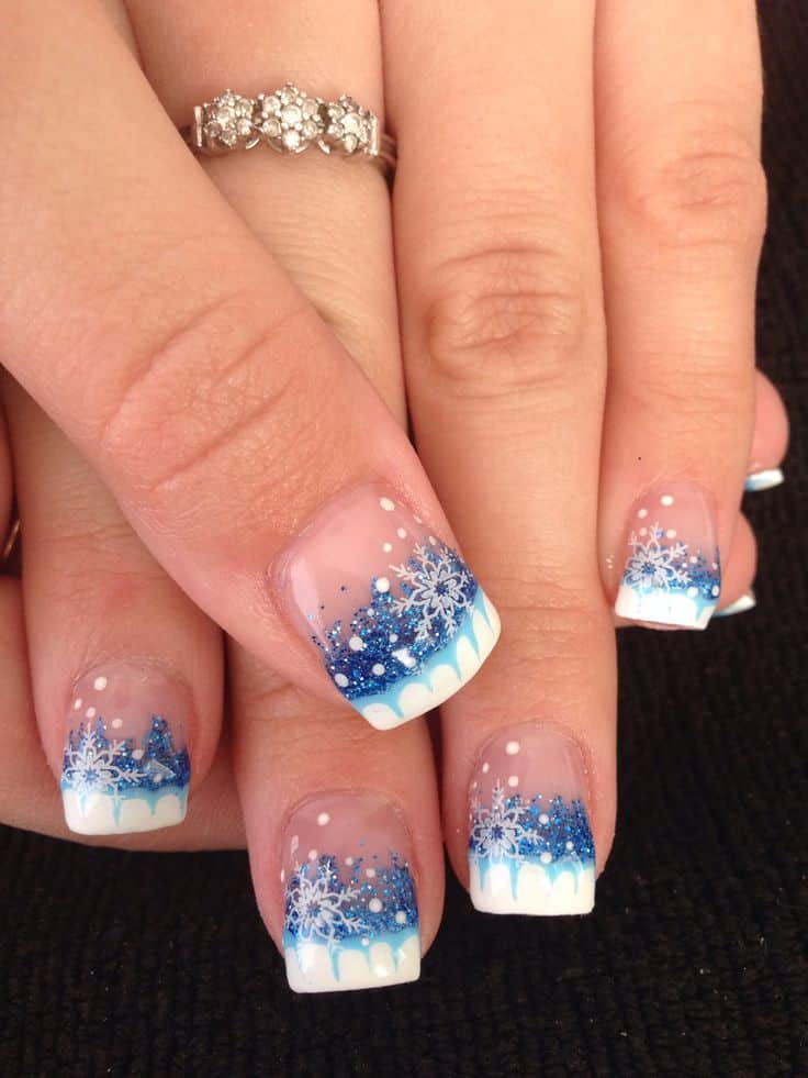 A view of blue ombre nails with snow flakes on top A view of blue ombre nails with snow flakes on top